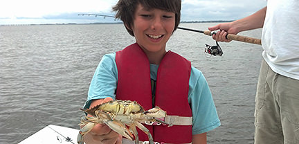 Boy with crab caught aboard Rock On Charters.